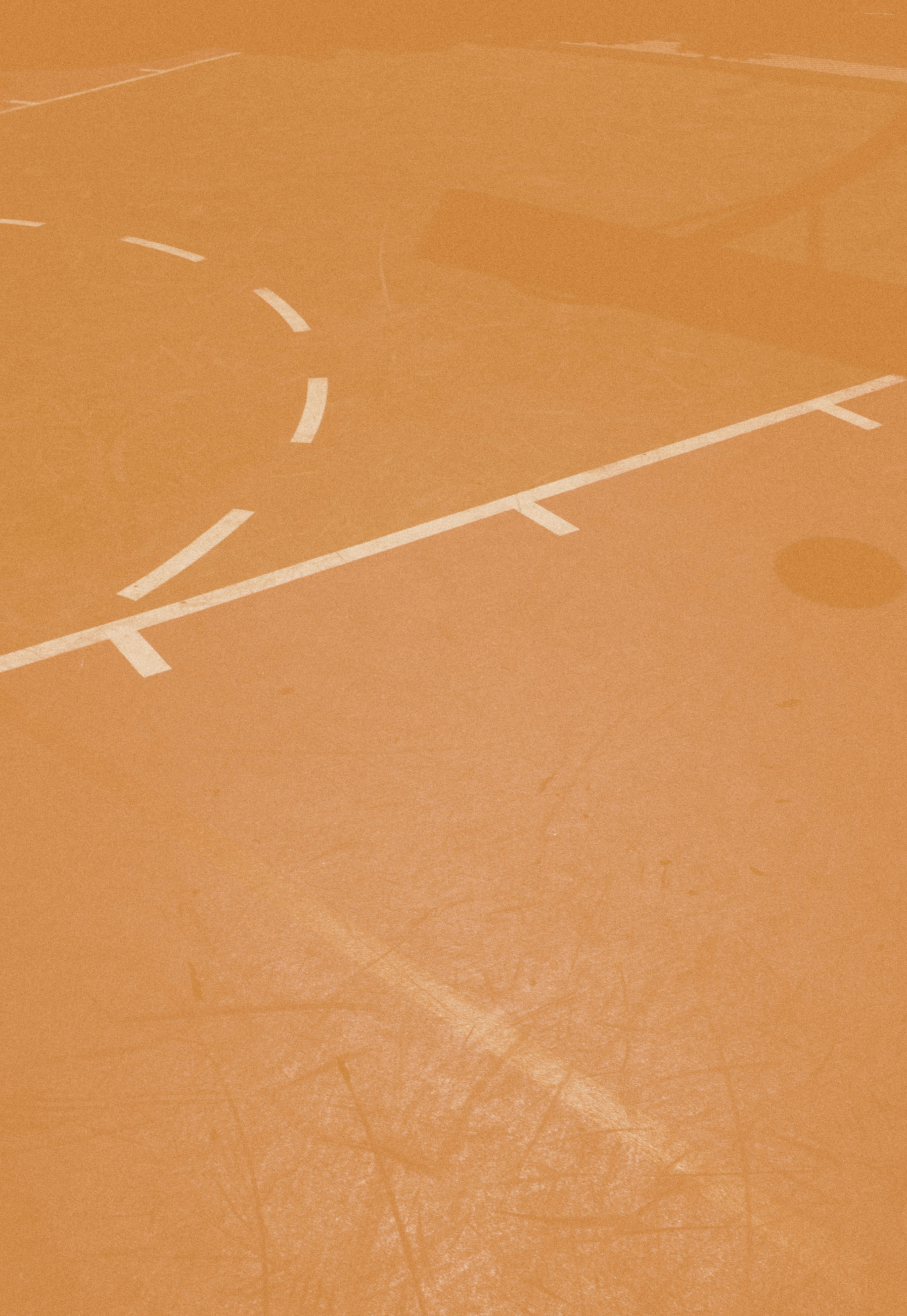 person taking a photo of orange basketball court